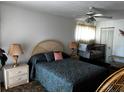 Bedroom featuring a patterned comforter, end tables with lamps, and ceiling fan at 2659 Crown Ct # 11, Kissimmee, FL 34741