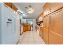 Spacious kitchen featuring granite countertops, wood cabinets, white appliances, and tile flooring at 3160 Santa Cruz Dr, Kissimmee, FL 34746