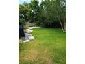 Spacious backyard with lush green grass, stepping stones, and mature trees providing shade at 3231 Lowndes Dr, Winter Park, FL 32792