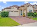 Charming single-story home featuring a stone facade, well-manicured landscaping and brick paver driveway at 3366 Puxton Dr, Orlando, FL 32824