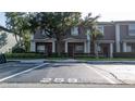 Townhome exterior featuring reserved parking spot, well-kept lawns, and mature trees at 3426 Wilshire Way Rd # 189, Orlando, FL 32829