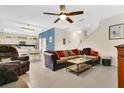 Spacious living area with an open floor plan, featuring tile floors and a comfortable sofa with throw pillows at 3881 Wind Dancer Cir, St Cloud, FL 34772