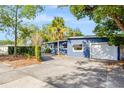 Exterior view of a home showcasing an attached one-car garage and manicured shrubs at 407 S Lakemont Ave, Winter Park, FL 32792