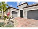 Home's exterior featuring stone accents, a brick driveway, and mature landscaping at 433 Via Abruzzi St, Kissimmee, FL 34759