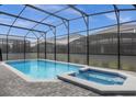 Sparkling pool and jacuzzi surrounded by a screened-in enclosure with brick pavers at 4473 Kaipo Rd, Davenport, FL 33897