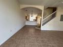 Open-concept living room with tile floors, archway into kitchen, staircase, and lots of natural light at 4726 Hemingway House St, Kissimmee, FL 34746