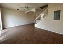 Bright and spacious living room featuring neutral paint, tile floors, a ceiling fan, and staircase at 4726 Hemingway House St, Kissimmee, FL 34746
