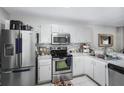 Well-lit kitchen with stainless steel appliances, white cabinets, and stylish backsplash at 5077 Ernst Ct # 3, Orlando, FL 32819