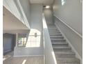 Bright foyer staircase with carpeted steps, modern railing, and beautiful natural light at 511 Elbridge Pl, Kissimmee, FL 34758