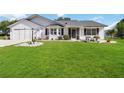 Beautiful single-Gathering home featuring a lush green lawn and attached garage at 5919 Mcenroe Ct, Leesburg, FL 34748