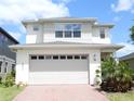 Charming two-story home with a brick driveway, large garage, and well-maintained landscaping at 6617 Harper Way, Harmony, FL 34773