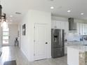 Bright kitchen with stainless steel appliances, white cabinetry, and a view of the entry at 6617 Harper Way, Harmony, FL 34773