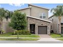 Beautiful townhome with manicured lawn, paved walkway, lovely stone details, and a nice shade tree at 721 Drop Shot Dr, Davenport, FL 33896