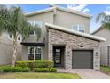 Charming two-story home featuring a stone accent facade, well-manicured lawn, and covered entryway at 721 Drop Shot Dr, Davenport, FL 33896