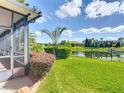 Scenic backyard with lush lawn, tropical landscaping, and a serene lake view beyond the black metal fence at 772 San Raphael St, Kissimmee, FL 34759