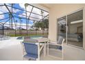 Tranquil screen enclosed patio includes a pool and a dining table near sliding glass doors to a bedroom at 8217 Fan Palm Way, Kissimmee, FL 34747