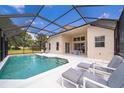 Enjoy a refreshing dip in the screened-in pool, complete with comfortable lounge chairs and an outdoor dining area at 8217 Fan Palm Way, Kissimmee, FL 34747