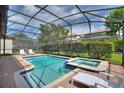 Inviting screened-in pool area featuring a sparkling pool, hot tub, and ample patio space for lounging at 9163 Wedge Dr, Davenport, FL 33896