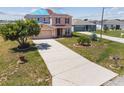Expansive front yard with green grass and mature landscaping for great curb appeal at 1038 Sabine Pl, Kissimmee, FL 34759