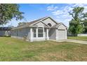Single-story home featuring a light gray facade and a well-maintained lawn with an attached garage at 108 Pearlwood St, Orlando, FL 32811
