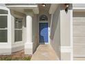 Close-up of the home's entrance featuring a blue front door, white pillar, and textured facade at 108 Pearlwood St, Orlando, FL 32811