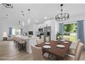 Modern kitchen with white cabinets, stainless steel appliances, island with seating, and adjacent dining area at 108 Pearlwood St, Orlando, FL 32811