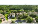 Aerial view of homes in a lush community with mature trees and a pond at 12867 Woodmere Close Dr, Windermere, FL 34786