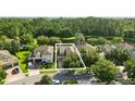 Aerial view of homes in a lush community with mature trees and a pond at 12867 Woodmere Close Dr, Windermere, FL 34786