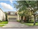 Charming home featuring a two-car garage, brick driveway, and mature landscaping at 12867 Woodmere Close Dr, Windermere, FL 34786