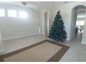 Spacious living room with tile floors, neutral paint, and a large Christmas tree adding festive cheer at 12867 Woodmere Close Dr, Windermere, FL 34786