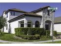 Charming home exterior with stucco and stone accents, landscaped yard, and a corner lot near a street intersection at 15079 Guava Bay Dr, Winter Garden, FL 34787