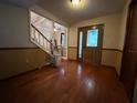 Inviting entryway featuring hardwood floors, a wooden door with decorative glass, and a staircase with a chairlift at 1835 Harbor Blvd, Kissimmee, FL 34744
