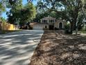 View of home exterior showing long driveway, 2 car garage, and landscaping with mature trees at 1835 Harbor Blvd, Kissimmee, FL 34744