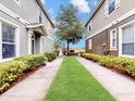 Inviting walkway lined with lush greenery leading to the front of the home at 1933 Estancia Cir, Kissimmee, FL 34741