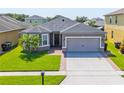 Exterior shot of a single Gathering home showing the garage and landscaped front yard at 2040 Patriot Way, St Cloud, FL 34769