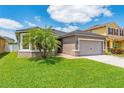 Well-maintained single Gathering house with a green lawn and a palm tree in the front yard at 2040 Patriot Way, St Cloud, FL 34769
