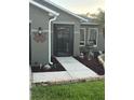 Charming front entrance with a secure gate, decorative plants, and a unique personalized 'Woodard' welcome sign at 2206 Hunters Greene Dr, Lakeland, FL 33810