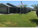 Well-maintained single-story home with lush green lawn and palm trees offers curb appeal at 2206 Hunters Greene Dr, Lakeland, FL 33810