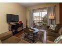 Cozy living room features comfortable seating and a private balcony with neighborhood views at 2301 Butterfly Palm Way # 303, Kissimmee, FL 34747