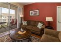 Comfortable living room offers a sliding door to a private balcony overlooking the neighborhood at 2301 Butterfly Palm Way # 303, Kissimmee, FL 34747