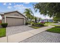 The home features a two car garage and paved driveway at 247 Bell Tower Xing W, Poinciana, FL 34759