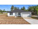 Inviting single-story home boasts a manicured lawn, modern front door, and an attached garage at 2639 Sw 162Nd Street Rd, Ocala, FL 34473