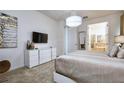 Spacious main bedroom featuring plush carpet, chandelier, and access to the ensuite bathroom at 2649 Calistoga Ave, Kissimmee, FL 34741