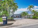 Charming light blue home with lush tropical landscaping and a covered carport at 302 E Drury Ave, Kissimmee, FL 34744