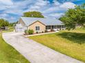 Inviting exterior of a single-story home with a long driveway and a well-maintained lawn and metal roof at 3048 Cherokee Rd, St Cloud, FL 34772
