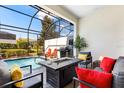 Relaxing screened patio with modern seating area and grill next to refreshing pool at 313 Captiva Dr, Davenport, FL 33896