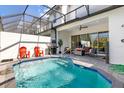 Beautiful screened-in pool with chairs, grill, and seating area for outdoor relaxation and fun at 313 Captiva Dr, Davenport, FL 33896
