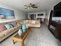 Spacious living room featuring tile floors, a large sofa and view into the dining area at 344 Winter Ridge Blvd # 344, Winter Haven, FL 33881
