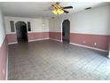 Open-concept living room with neutral tile flooring, and a half-painted accent wall at 344 Winter Ridge Blvd # 344, Winter Haven, FL 33881