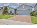 Attractive single-story home displaying a blue exterior, brick driveway, and well-maintained landscaping at 4327 Silver Creek St, Kissimmee, FL 34744